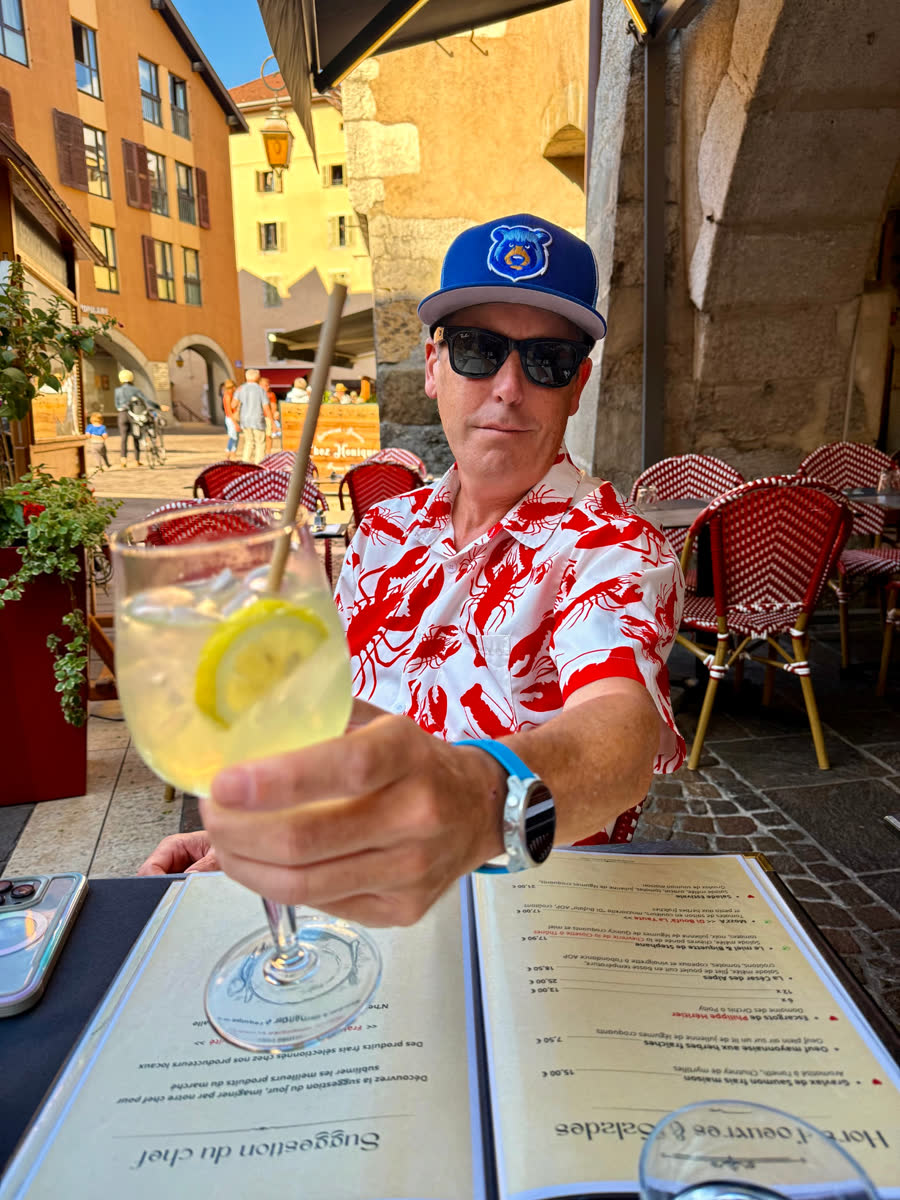 Munny raising a drink at a French cafe terrace